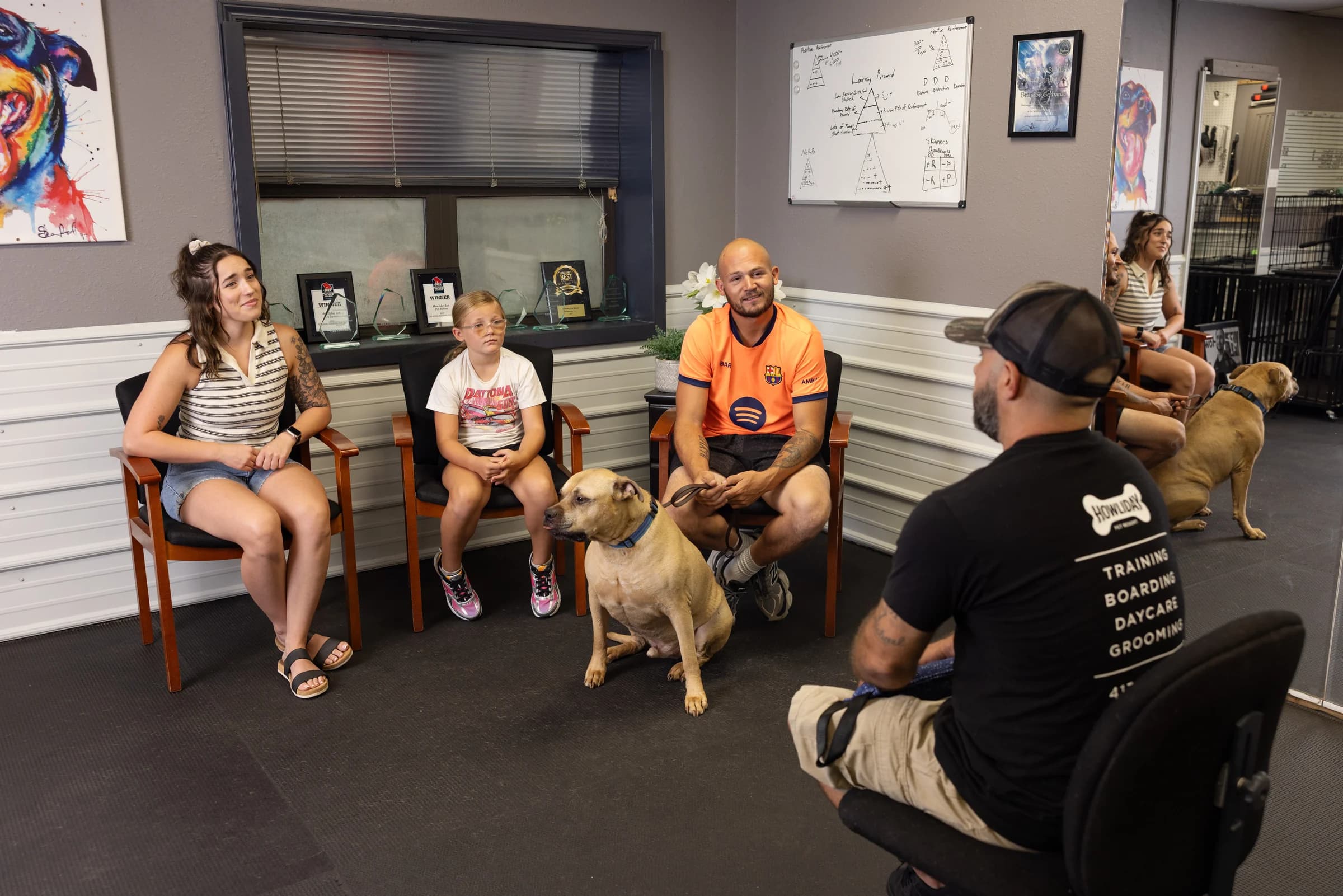 A Howliday Inn trainer consulting with a family and their dog in the training room